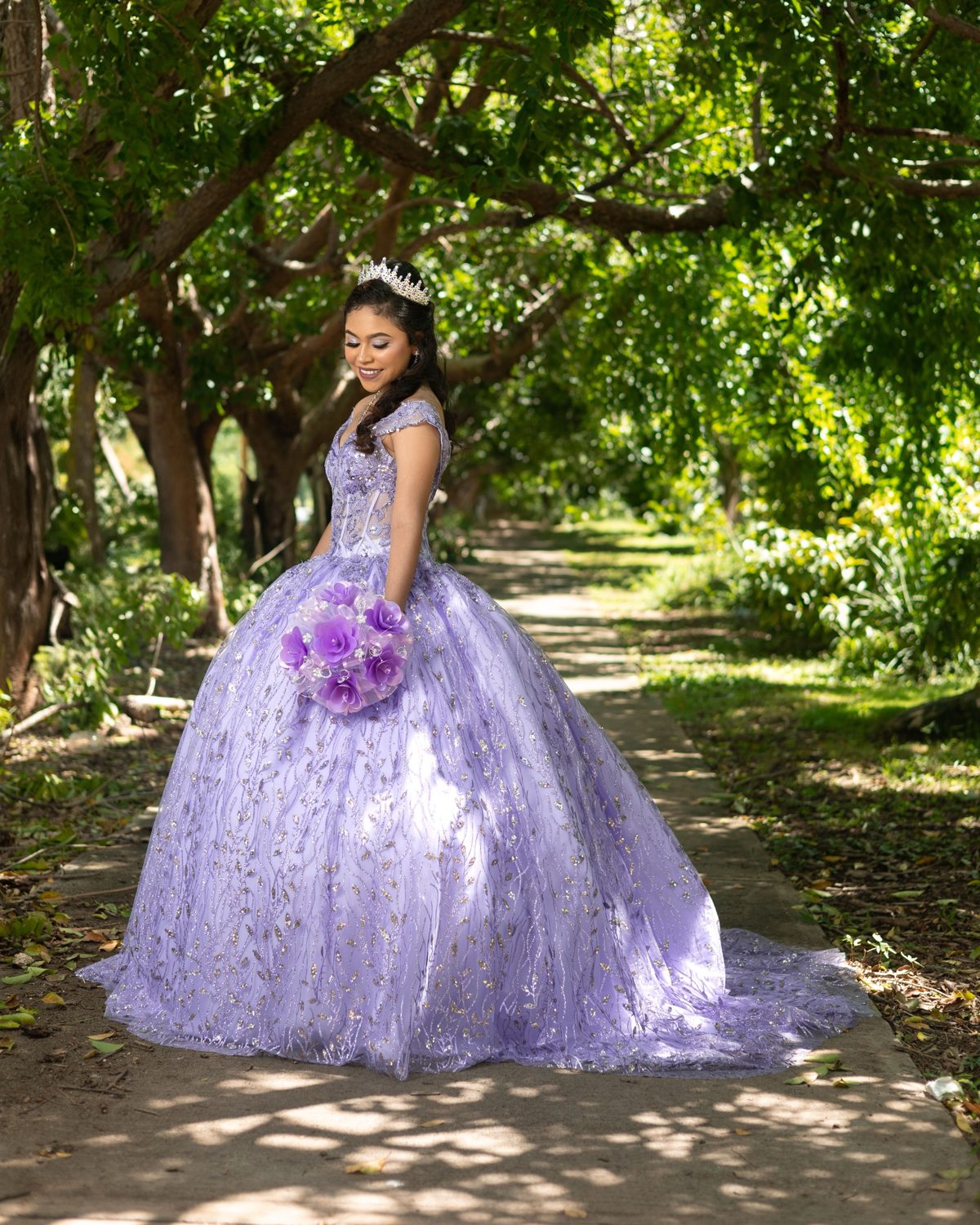 Camila Andrea con su vestido lila bajo los árboles